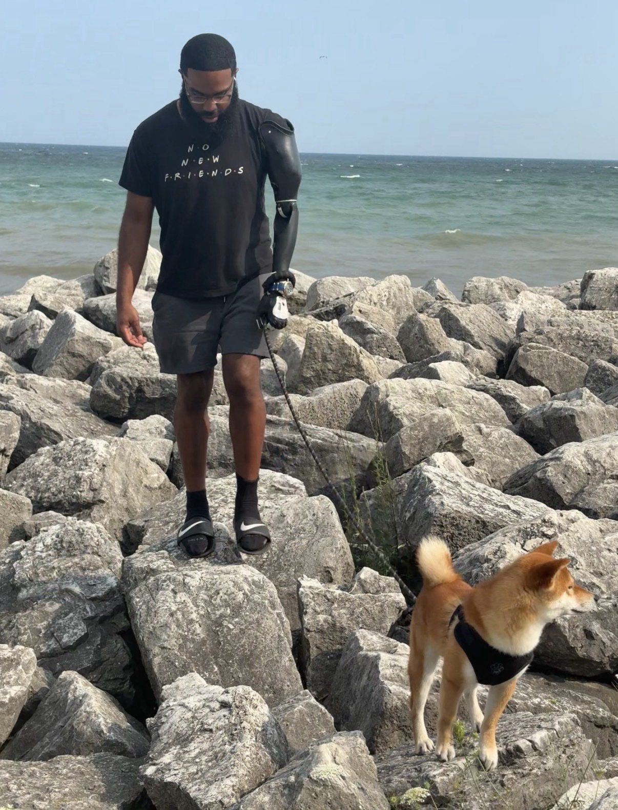 Jonathan Freeman and his dog Kota on the rocks by the lake